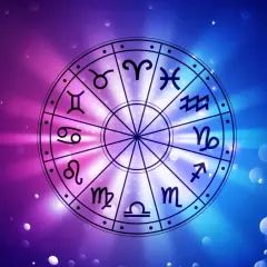 Koło zodiaku z symbolami, w tym Byk i Skorpion, na tle gradientu fioletowo-niebieskiego z rozmazanymi światłami.