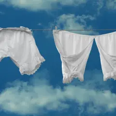Białe, koronkowe majtki suszą się na tle błękitnego nieba. Jakie sny o wolności przyniesie ten widok?