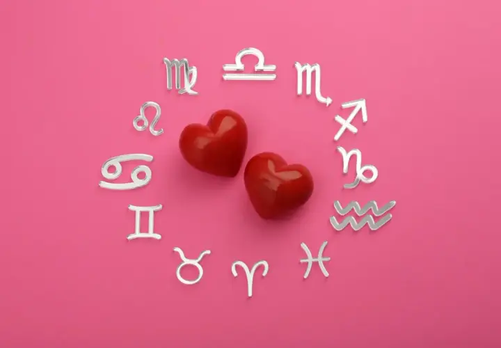 Dwa czerwone serca otoczone srebrnymi symbolami zodiaku. Dziś horoskop na dziś Waga miłosny zapowiada gorące uczucia.