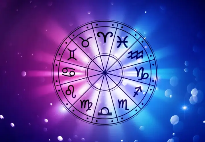 Koło zodiaku z symbolami, w tym Byk i Skorpion, na tle gradientu fioletowo-niebieskiego z rozmazanymi światłami.