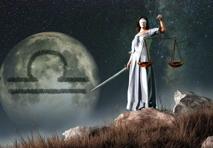 Kobieta z przepaską na oczach, trzymająca wagę i miecz, stoi na tle księżyca z symbolem Wagi. Ascendent w wadze.