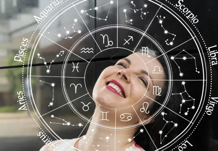 Uśmiechnięta kobieta na tle koła zodiaku. Sprawdź swój horoskop na jutro, zwłaszcza jeśli jesteś Lwem!